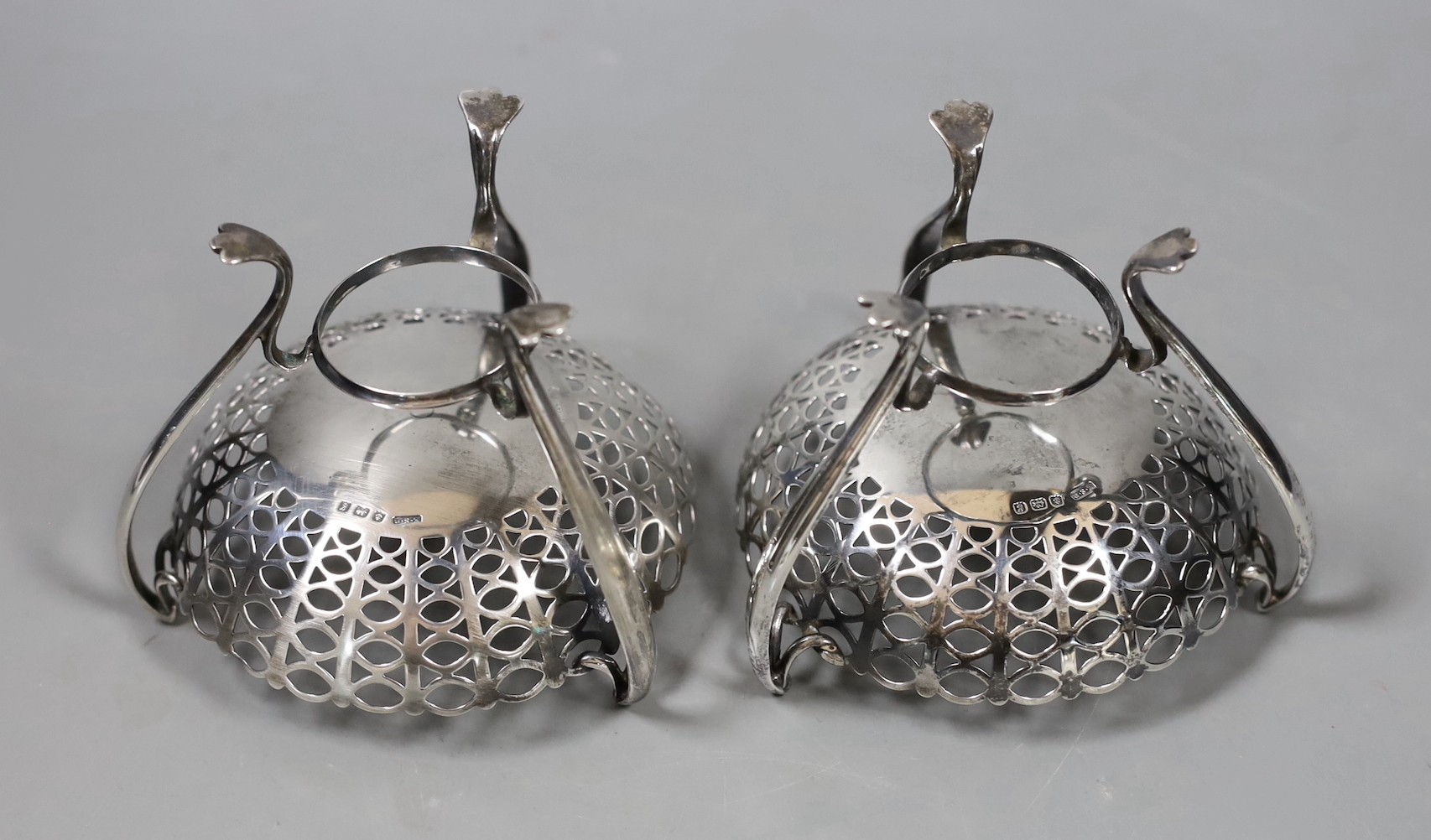 A pair of Edwardian pierced silver bon bon dishes, on raised tripod supports, E.S. Barnsley & Co, Birmingham, 1906, height 81mm, 5.8oz.